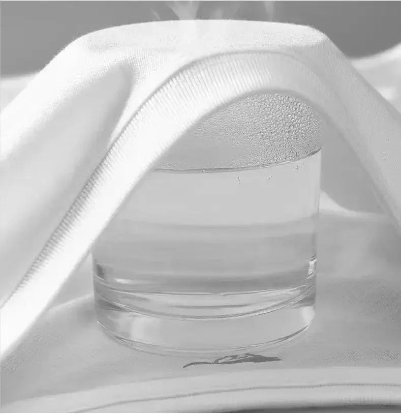 Steam rising from a glass of water placed on a white towel, emphasizing moisture and relaxation.